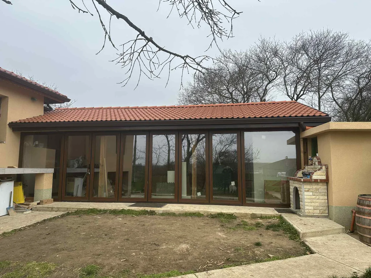 Dezelfde veranda met houtlook, waarbij de glazen voorgevel gesloten is.